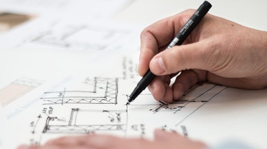 Stift mit Hand und Zeichnung